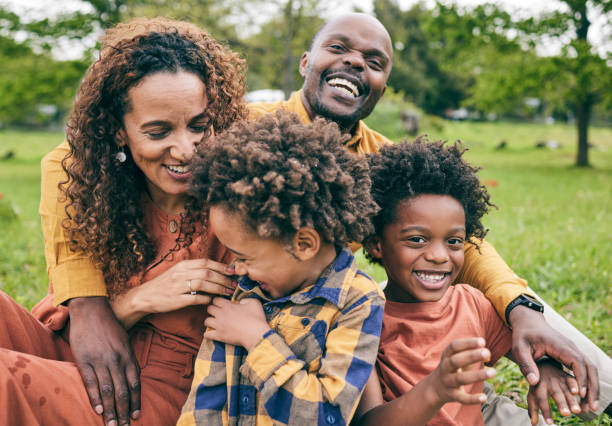 Black family smiling together in a park